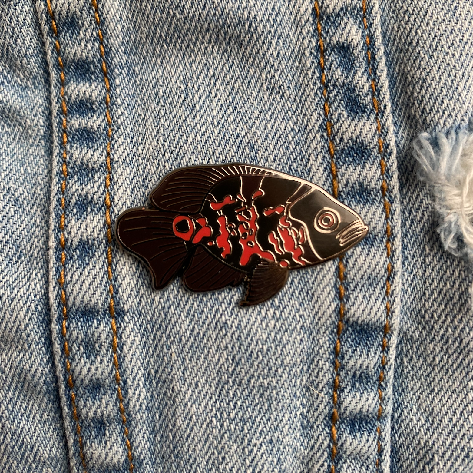 Tiger oscar cichlid hard enamel pin. Black, gray and orange fish pin.