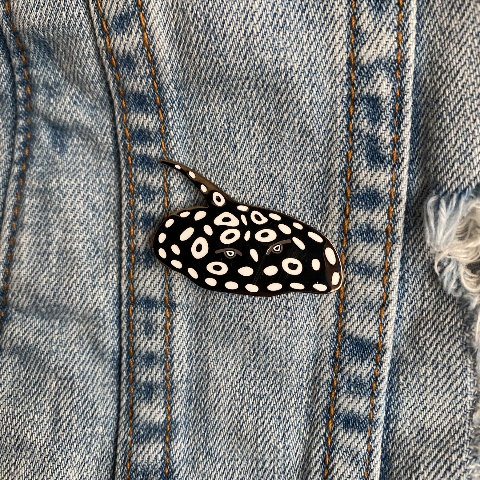 Black Diamond freshwater sting ray enamel pin from tank life apparel. Black with white dots and circles ray.